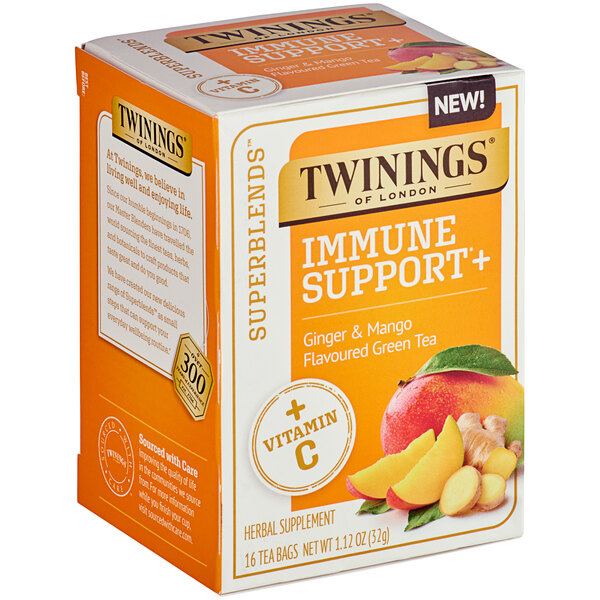 A box of Twinings Immune Support Green Tea with Mango and Ginger tea bags on a table.