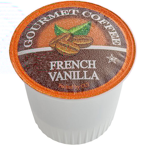 A white cup with an orange label filled with Caffe de Aroma French Vanilla coffee pods.