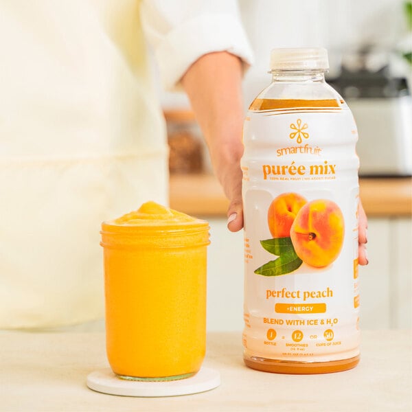 A woman holding a bottle of Smartfruit Perfect Peach puree juice.
