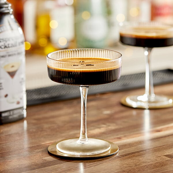 A table with two glasses of Java House Cold Brew Espresso Martini Mix and bottles of alcohol.