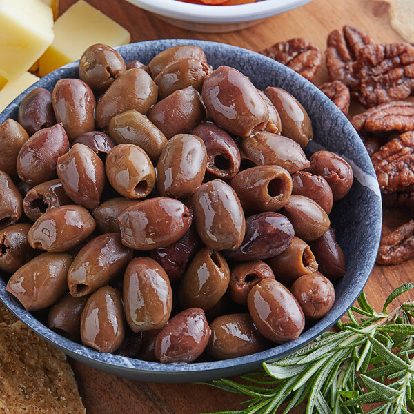 A bowl of Frutto d'Italia Pitted Taggiasca olives with cheese and crackers.