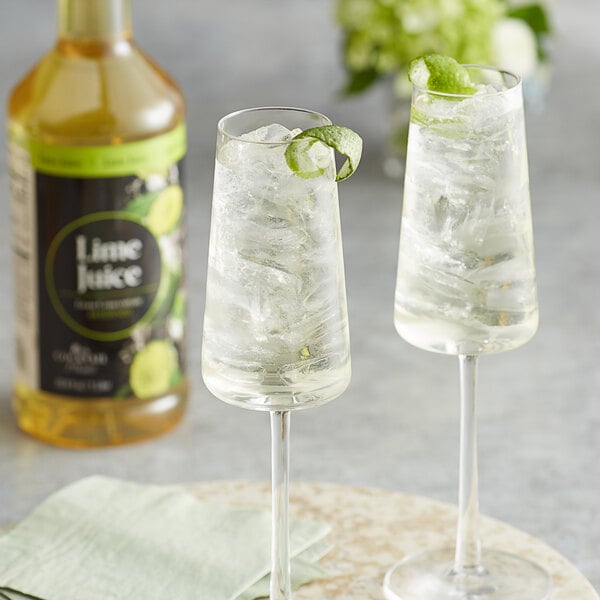 Two glasses of Regal Cocktail lime juice with ice and lime slices.