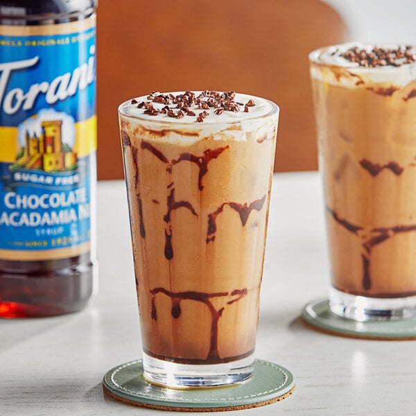 Two glasses of iced coffee with brown liquid and chocolate milkshakes with brown liquid.