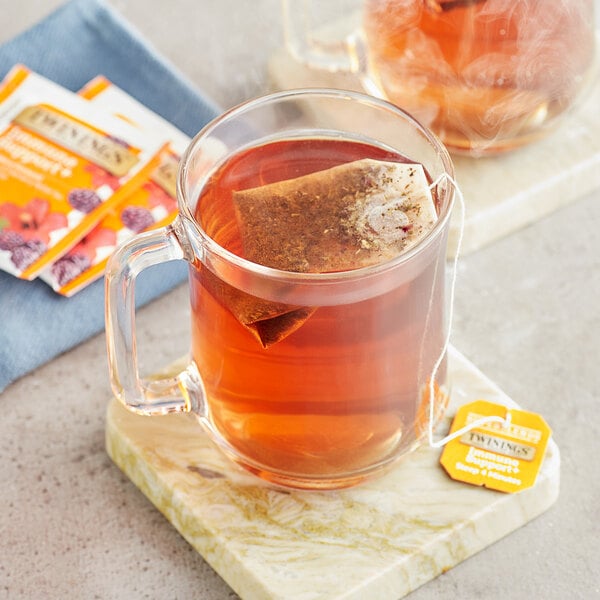 A glass mug of Twinings Immune Support tea with a tea bag in it.