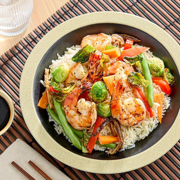 A bowl of rice topped with grilled shrimp and assorted vegetables.