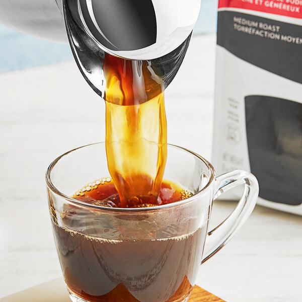 A coffee maker pouring Lavazza Classico coffee into a glass cup.