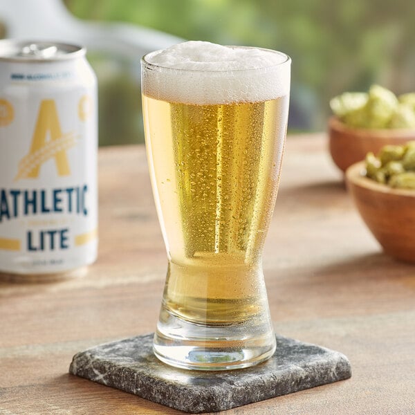 A can of Athletic Lite non-alcoholic beer on a table next to a glass of beer.