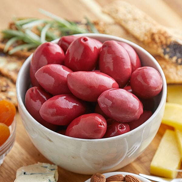 A white bowl filled with red Frutto d'Italia Cerignola olives.