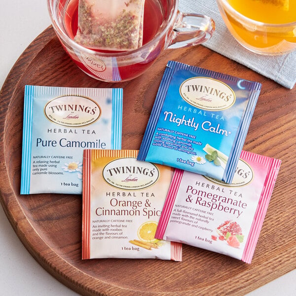 A wooden tray with a variety of Twinings herbal tea bags.