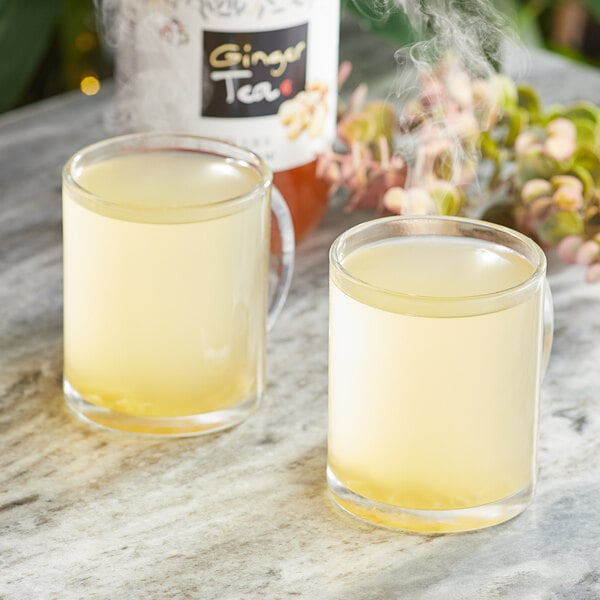 Two cups of Assi ginger tea on a table.