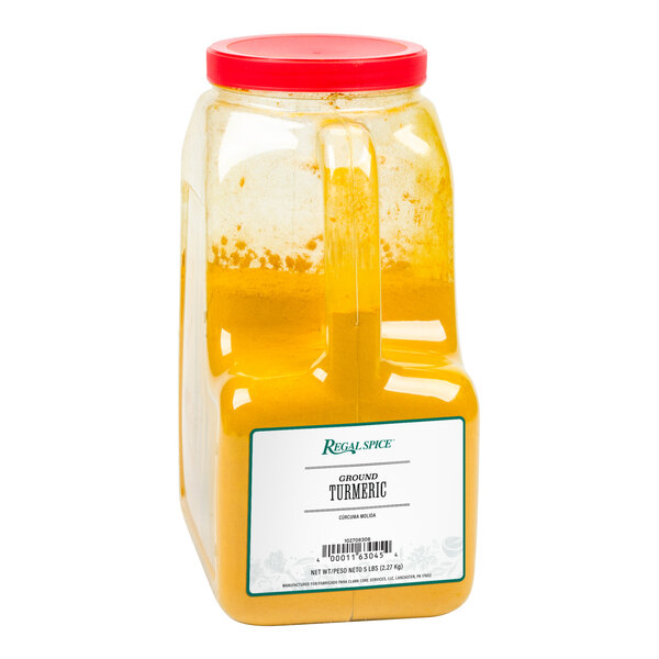 A plastic container of yellow ground turmeric with a red lid.