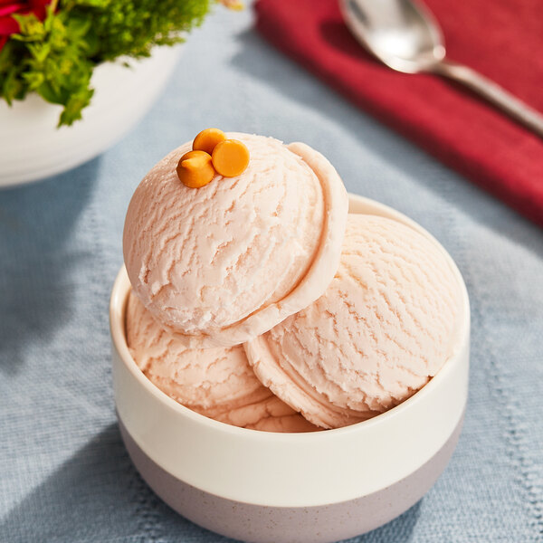 A bowl of Lloyd's Butterscotch ice cream with a spoon.