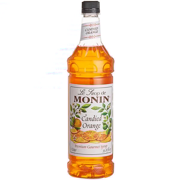 A close up of a Monin Premium Candied Orange Fruit Syrup bottle.