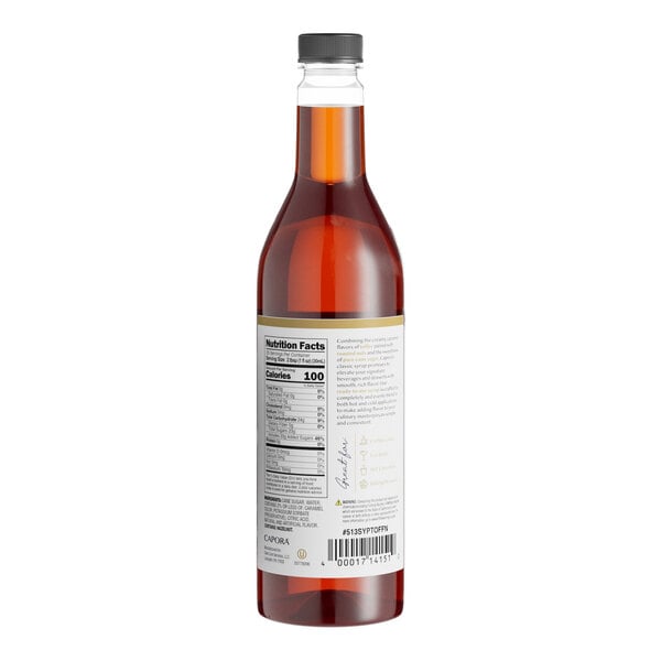 A close-up of a Capora Toffee Nut Flavoring Syrup bottle filled with brown liquid.