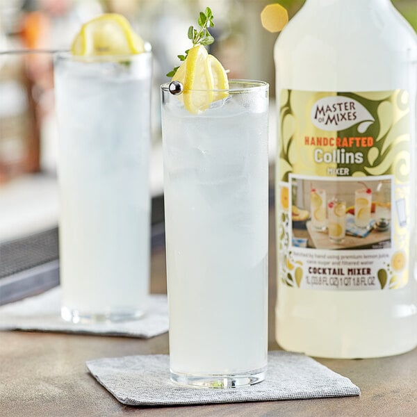 A glass of Master of Mixes Tom Collins Mix with lemon slices on the rim.