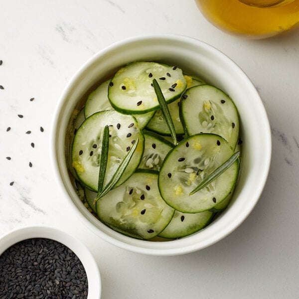 A bowl of cucumber slices with black sesame seeds.