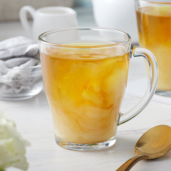 A glass cup of jasmine green tea with a Bossen jasmine green tea bag steeping in it.