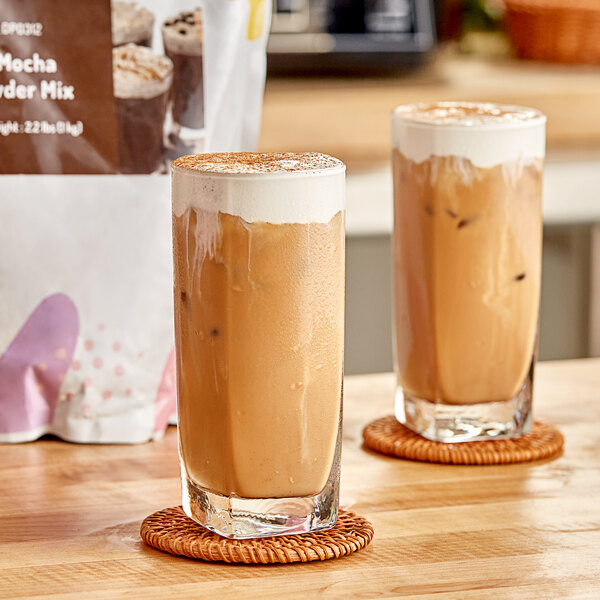 Two glasses of iced mocha with milk and foam.