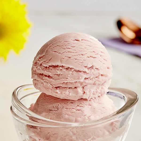 A close-up of a bowl of pink and white swirl ice cream.