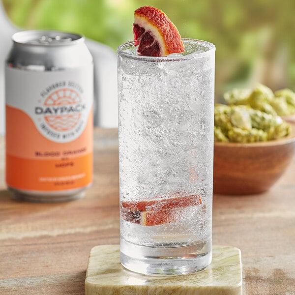 A glass of DayPack Blood Orange sparkling hop water with bubbles and a slice of orange on top.