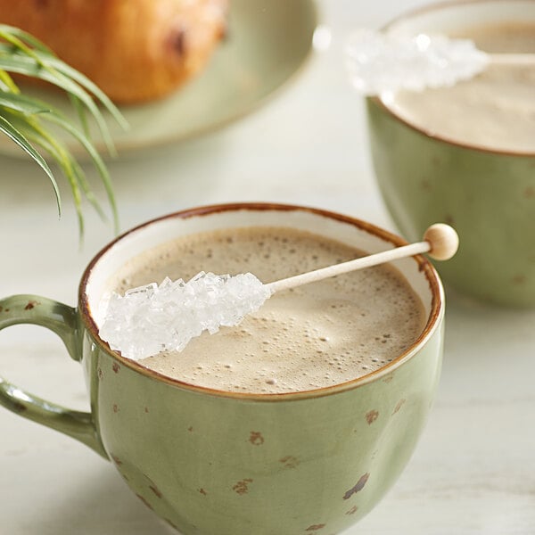 A cup of coffee with a Rose's Dryden and Palmer white sugar stick in it.