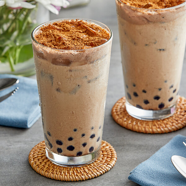 Two glasses of brown Fanale Tiramisu bubble tea with brown toppings and black bubbles.