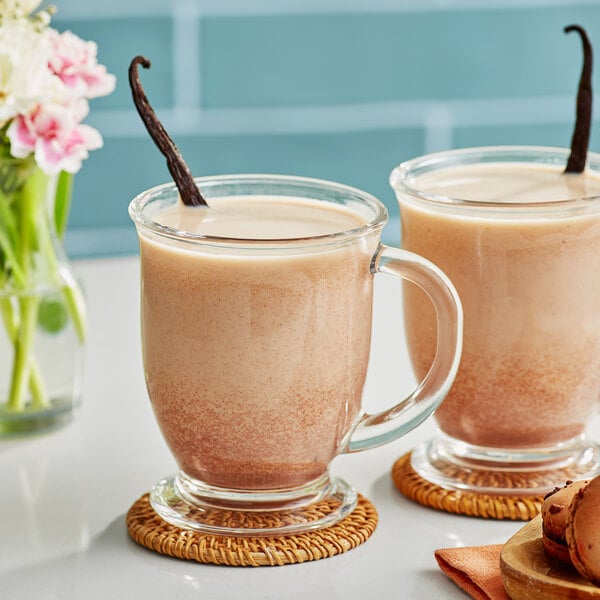 Two glasses of Dona Unsweetened Masala Chai concentrate with vanilla beans.
