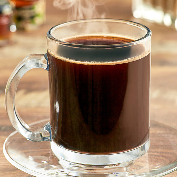 A glass mug filled with Ellis French Vanilla Brulee coffee with steam rising from it.