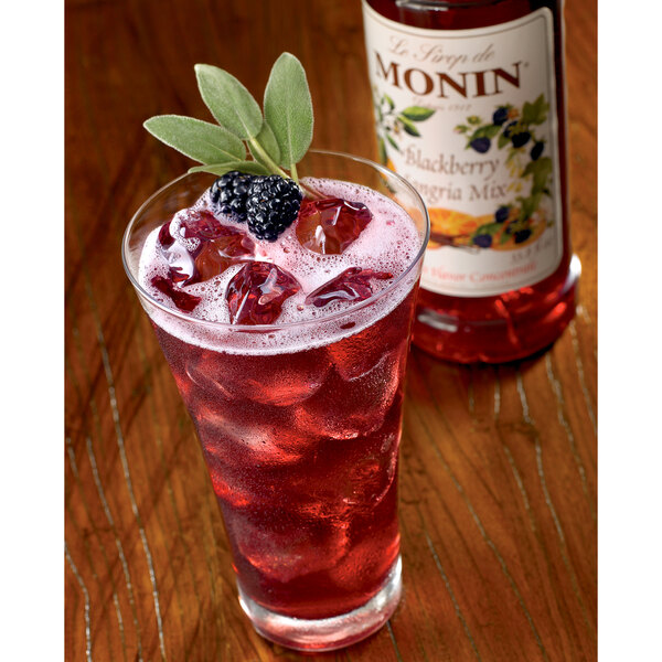 A glass of Monin blackberry sangria mix with ice and berries.