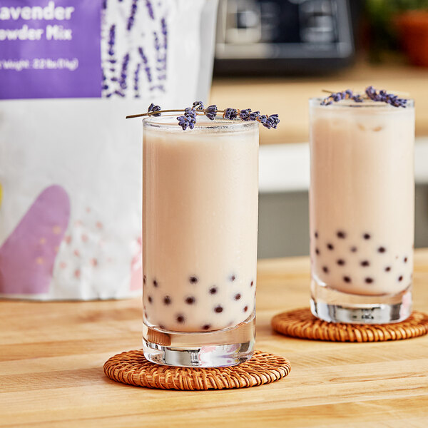 Two glasses of lavender bubble tea with lavender sprigs on top.