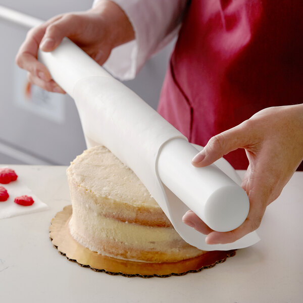 A person using Satin Ice ChocoPan to decorate a cake.