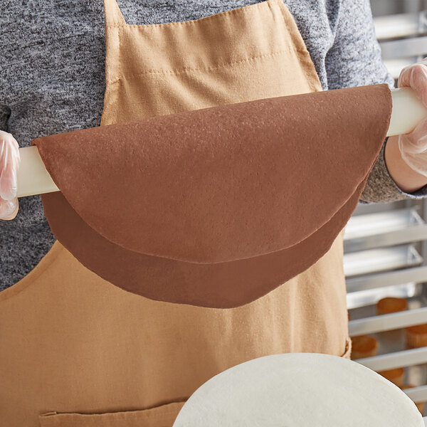 A woman holding a roll of Satin Ice Brown Bombshell Chocolate Flavored Fondant.