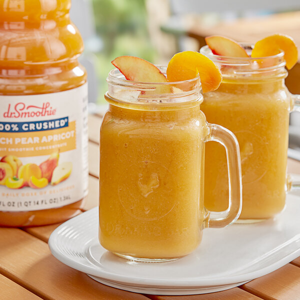 Two glass mugs filled with peach smoothie on a table.