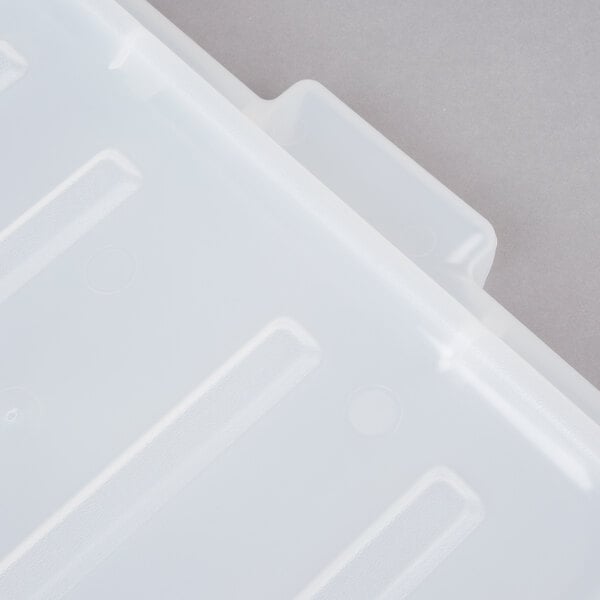 A close-up of a white Vollrath Traex food storage box lid with a line in it.