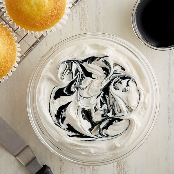 A bowl of white frosting swirled with black frosting.