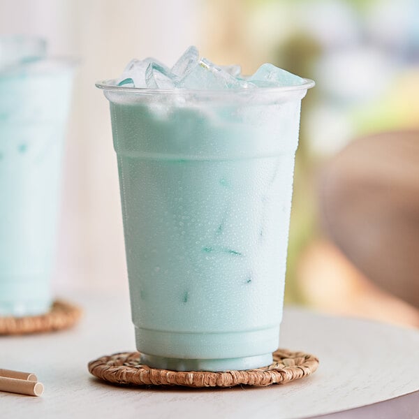 A close up of a blue Capora Cotton Candy frappe with ice.