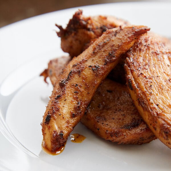 Grilled chicken seasoned with Regal Cajun Spice on a white plate.