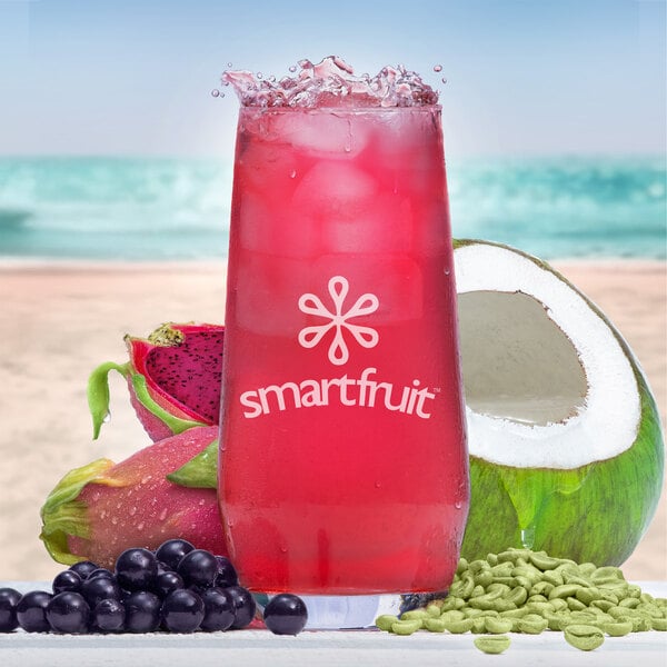 A close up of a glass of pink Smartfruit Recharge Dragon Fruit and Elderberry Refresher with fruit.