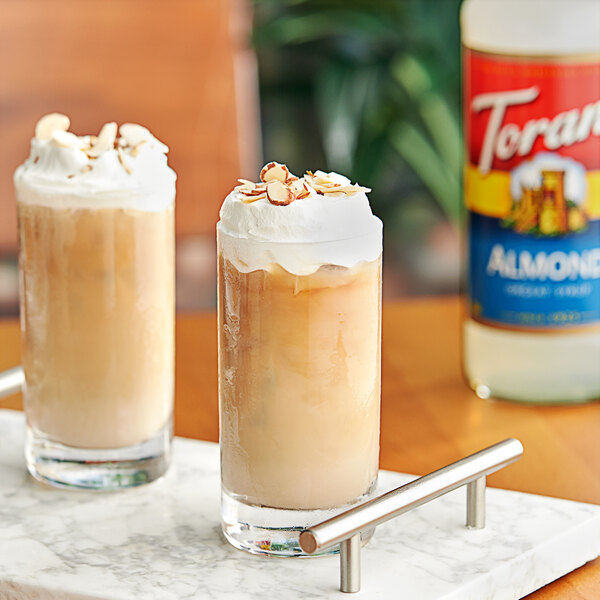 Two glasses of iced coffee with Torani Almond syrup and whipped cream.