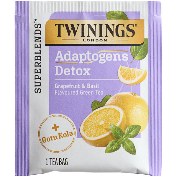 A purple and white box of Twinings Detox Adaptogens Grapefruit & Basil Green Tea with a slice of grapefruit on the side.