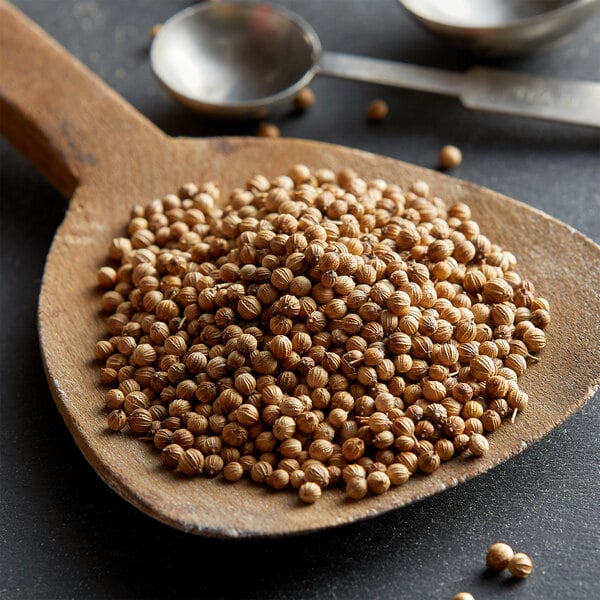 A wooden spoon filled with Regal whole coriander seeds.