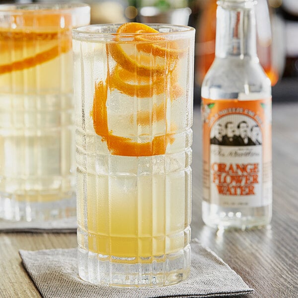A glass of water with orange slices in it.