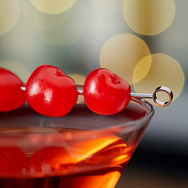 A close up of a red drink garnished with a Regal Maraschino Cherry.