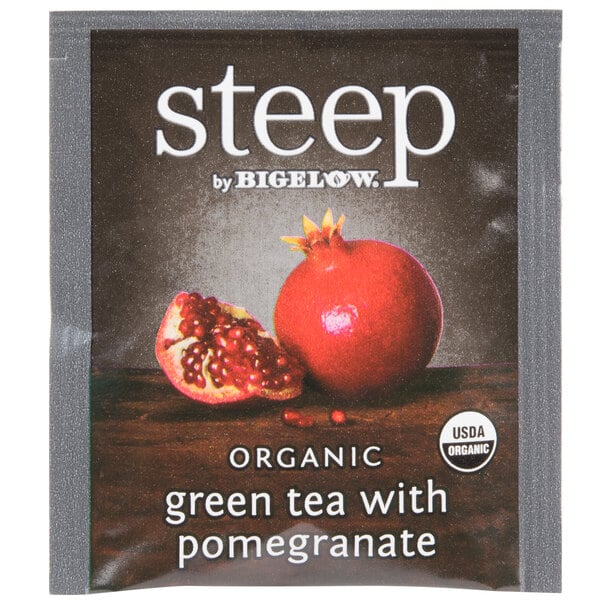 A package of Steep by Bigelow organic green tea with pomegranate tea bags on a table.