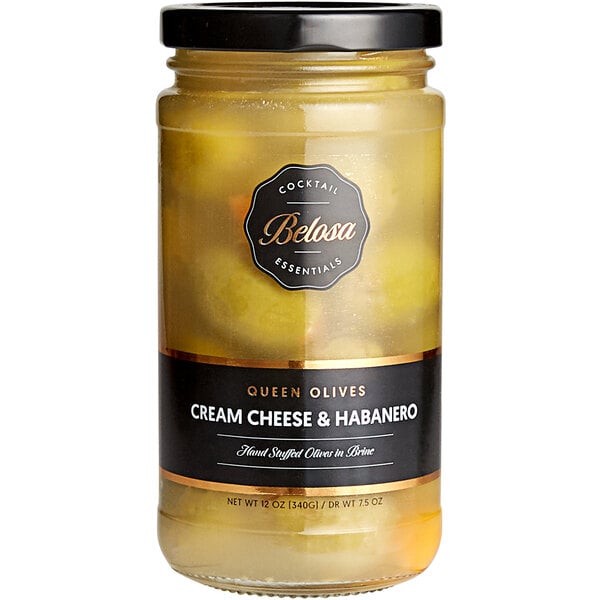 A jar of Belosa Cream Cheese & Habanero Stuffed Queen Olives on a table with a black label.