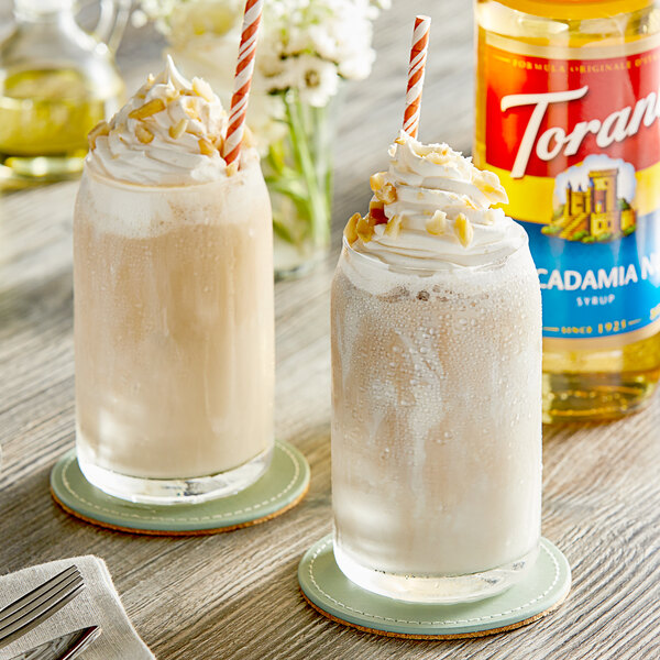 Two glasses of milkshakes with Torani Macadamia Nut Flavoring Syrup and straws.