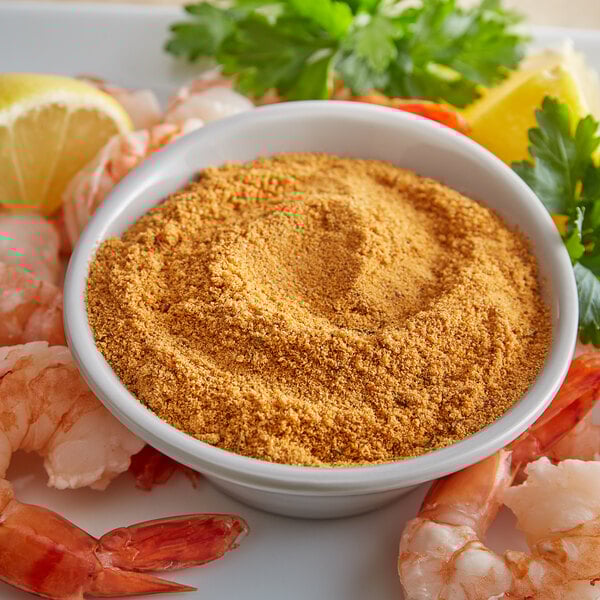 A bowl of shrimp and lemons seasoned with J.O. No. 1 Seafood Seasoning on a table.