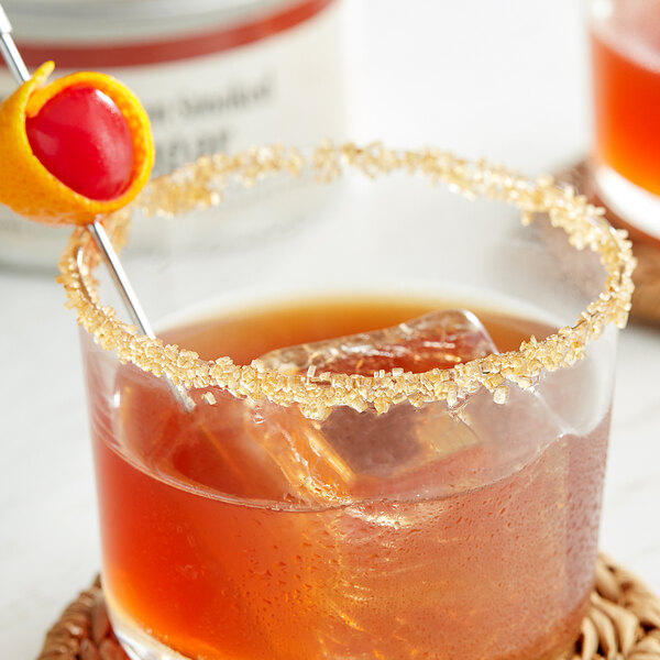 A drink with a Bourbon Smoked Sugar rim and a straw with a cherry.