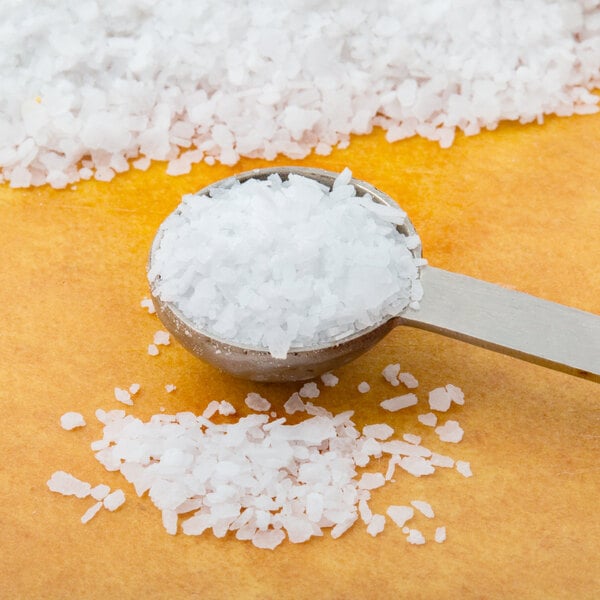 A spoon filled with Morton Coarse Kosher Salt on a pile of white salt.