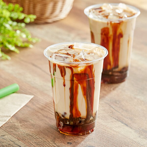 A close up of two cups of iced coffee with brown Fanale Carmelized Brown Sugar syrup and ice cubes.